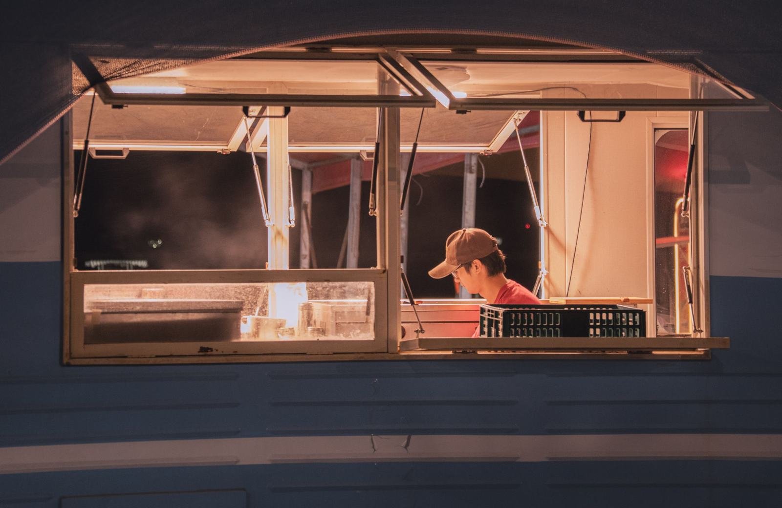 Cook working inside a food truck at night